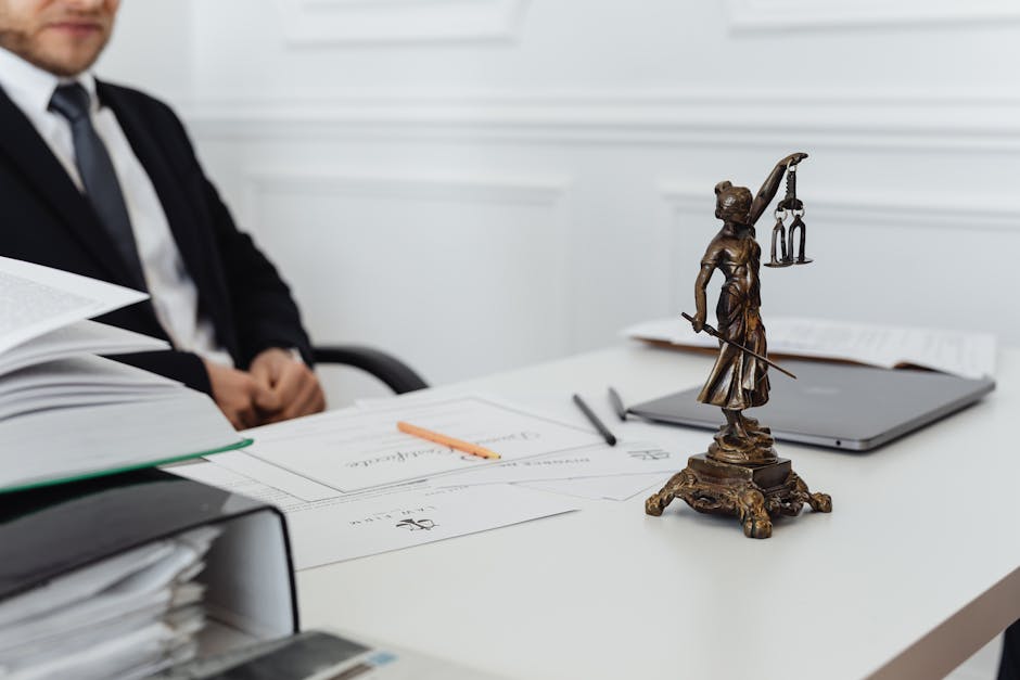 Legal professional at desk with Lady Justice statue, documents, and laptop, representing AI legal advice.