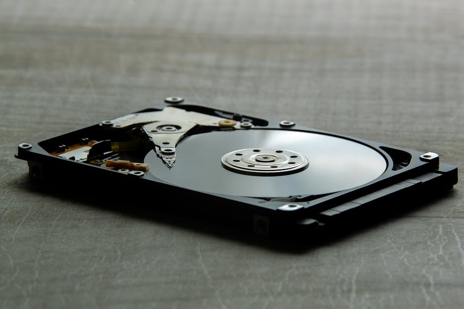 Internal view of an opened hard drive (HDD) showing platter and read/write head, symbolizing data storage for cloud server backups.