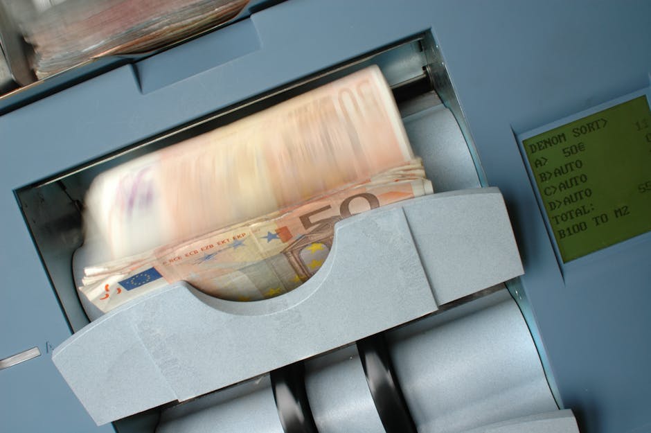 A money counting machine rapidly processes blurred 50 Euro banknotes, symbolizing efficient and automated workflows.