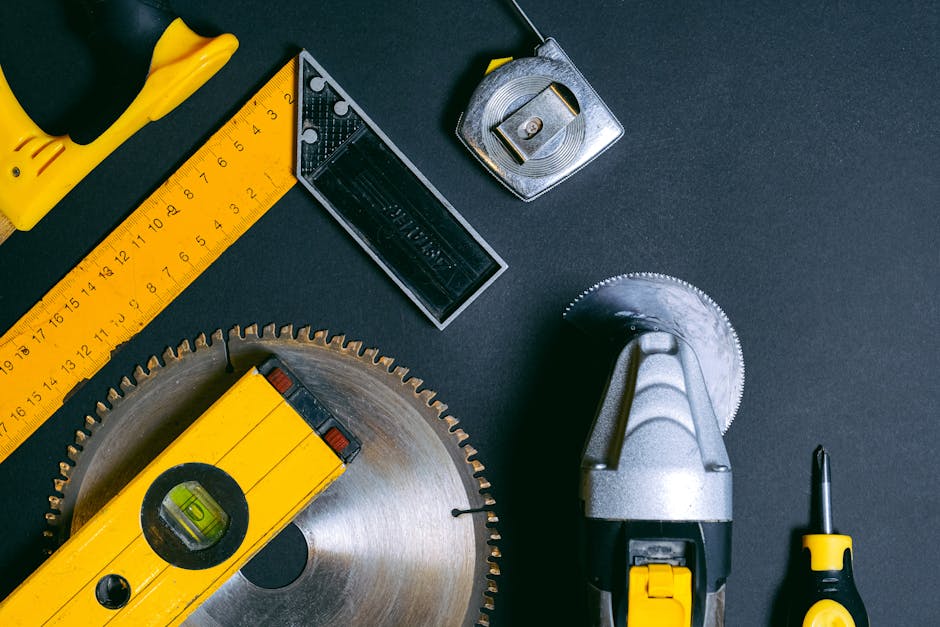 Assortment of yellow and metallic hardware tools: ruler, level, saw blade, tape measure, and screwdriver, ideal for Shopify.