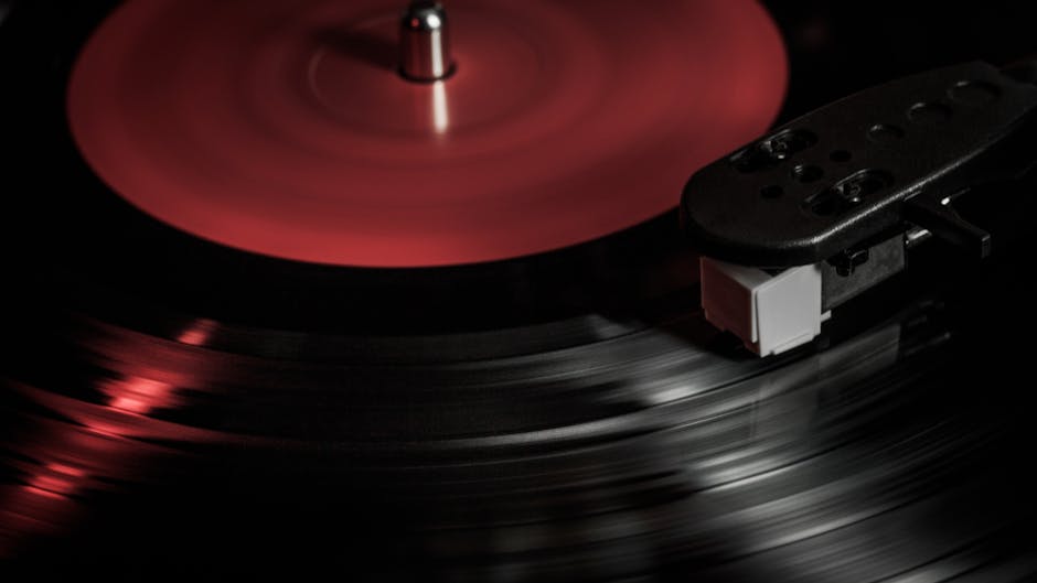 Spinning red-labeled vinyl record on a turntable, representing traditional music discovery in the age of AI.