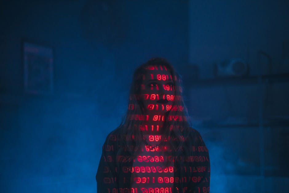 Person with red binary code projected on face and body, symbolizing AI protecting digital identity from online fraud.