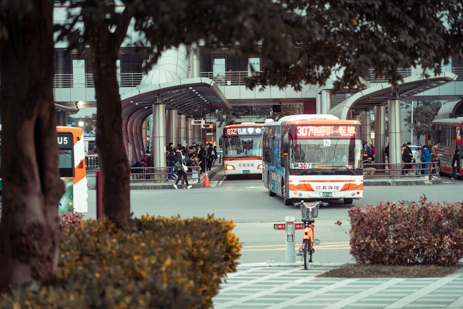 Buses and commuters at a busy city bus station, demonstrating modern urban public transportation.