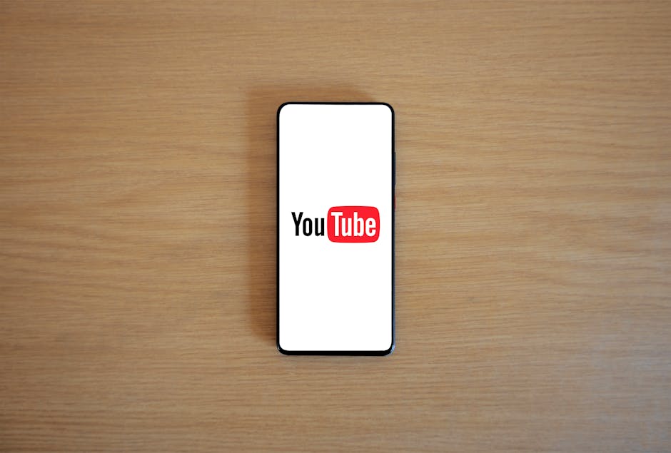 Smartphone displaying YouTube logo on screen, representing AI's role in scripting YouTube videos.